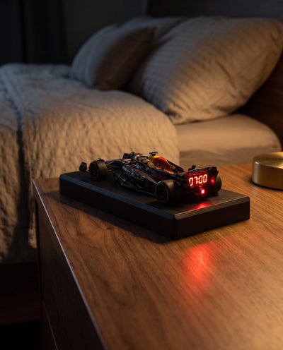 F1 alarm clock glowing red at night on a nightstand